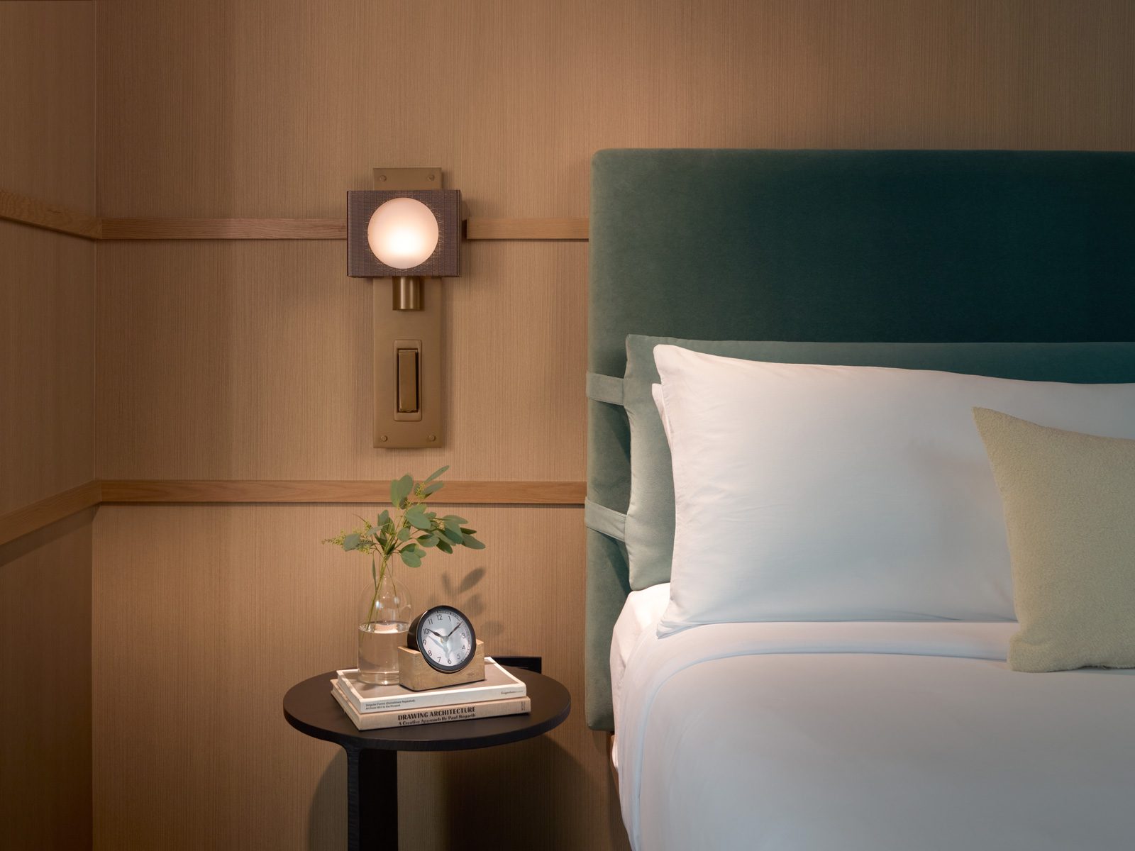 Luxury bed with upholstered headboard and wood paneled wall at the Harbor Grand Hotel in New Buffalo, Michigan