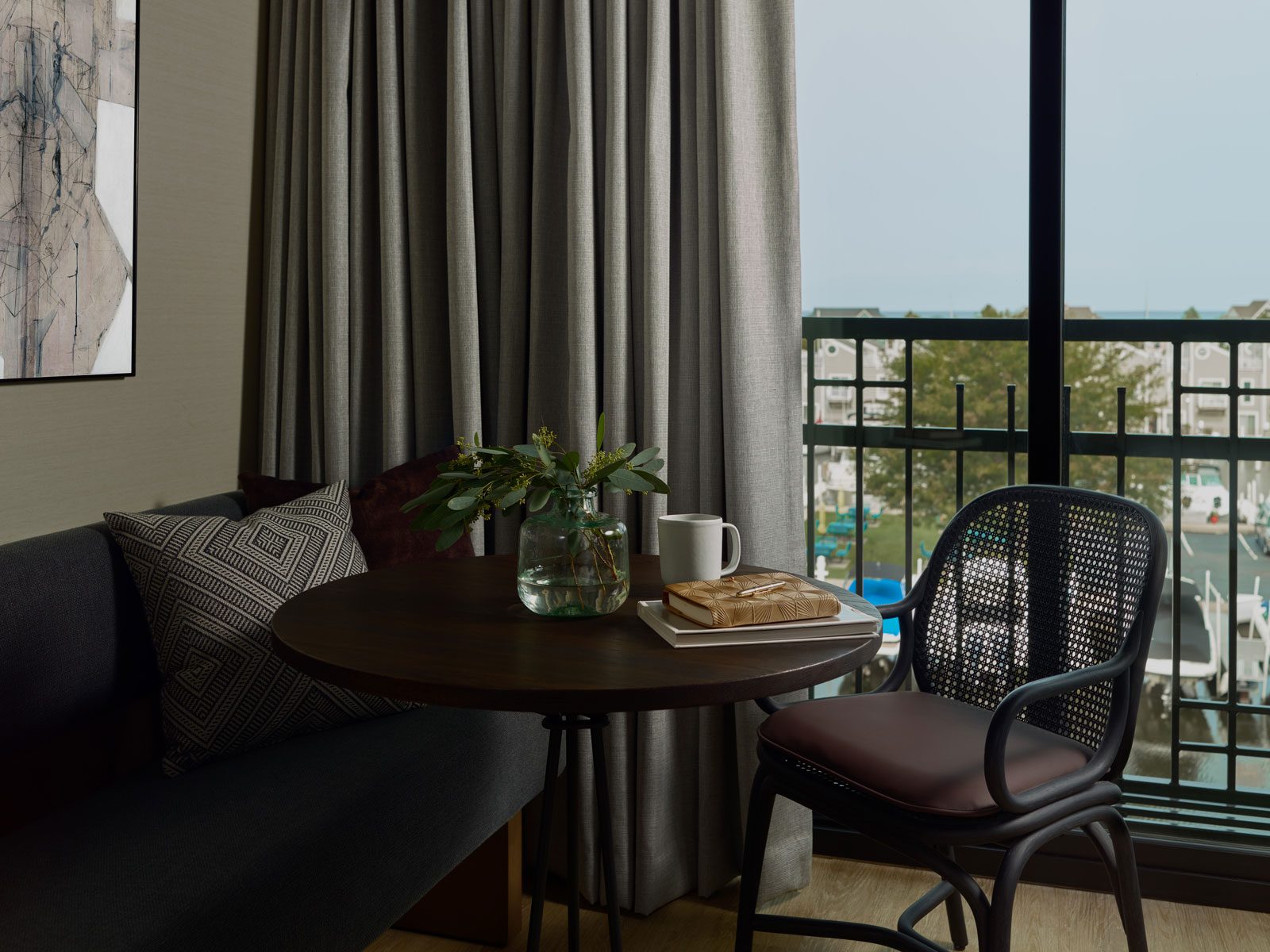 Cafe table and seating in front of a window overlooking the New Buffalo harbor