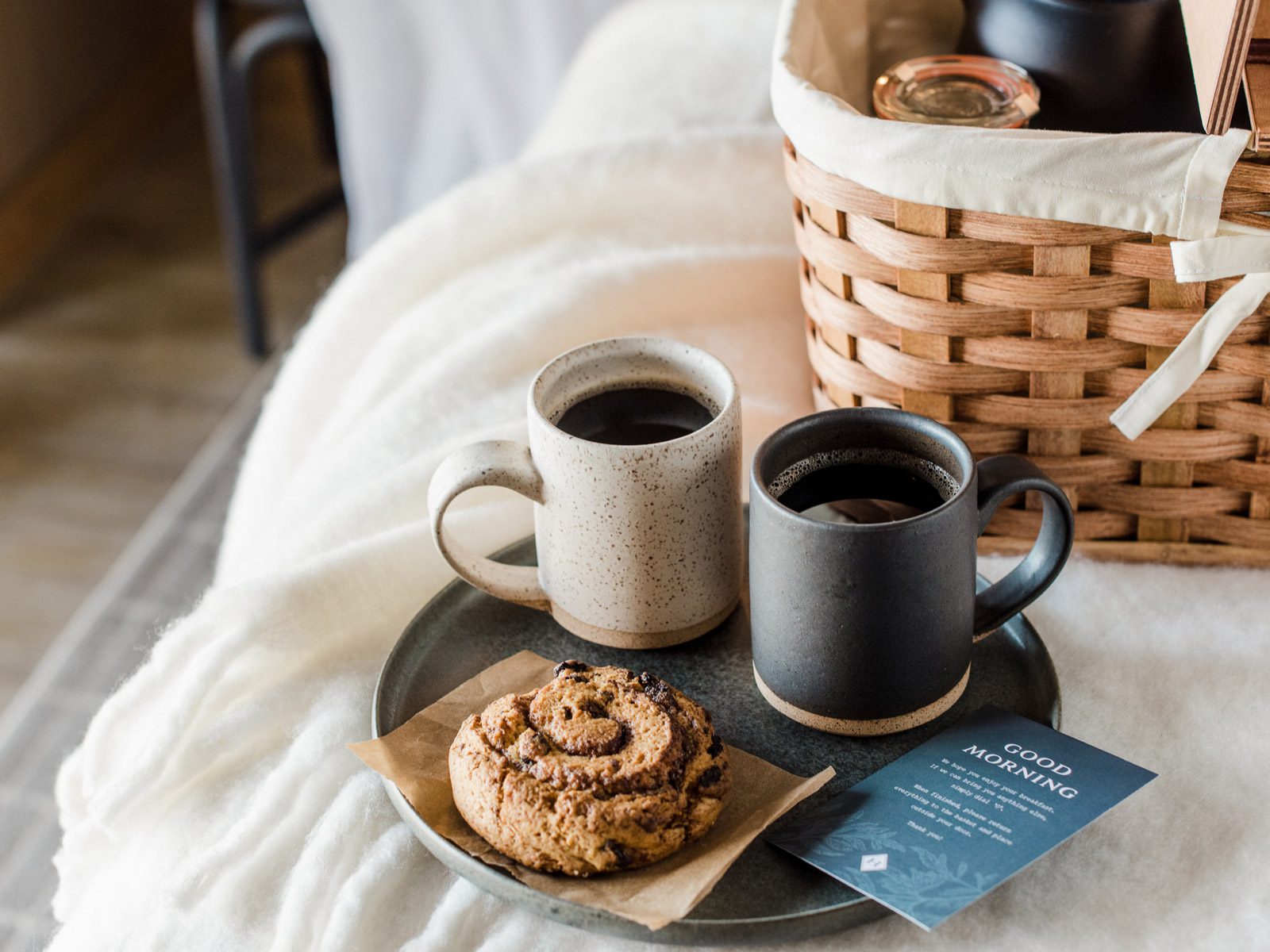 Breakfast in bed scene with coffee and pastry in a guestroom at The Harbor Grand Hotel in New Buffalo, Michigan.
